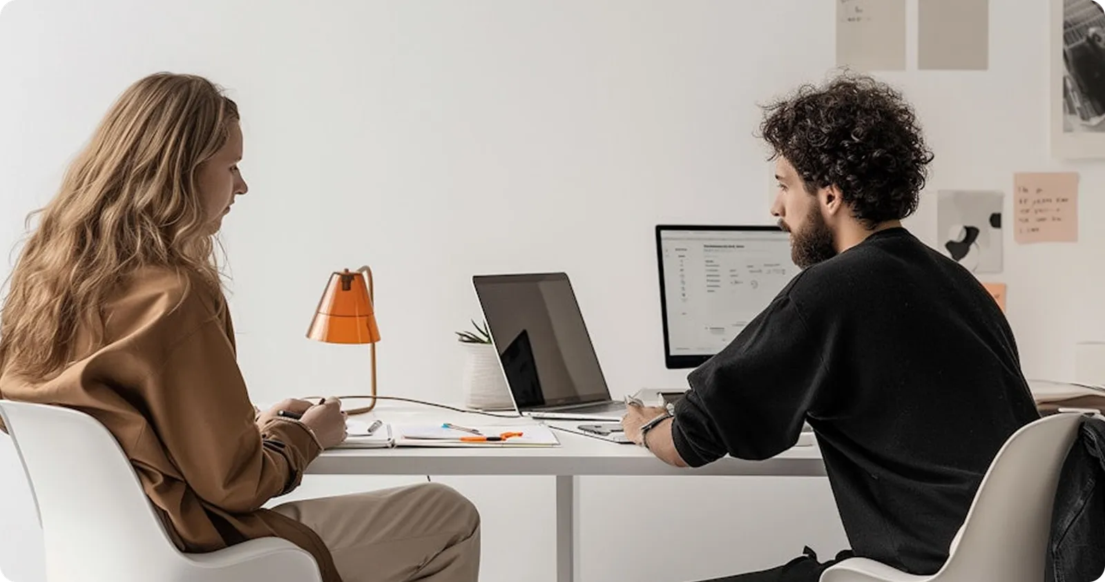 Two people working at desks in a bright, quiet office