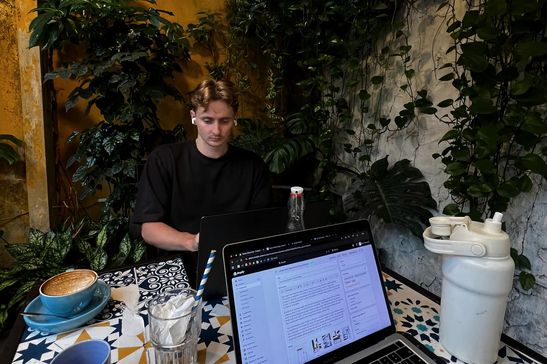 Jordan Macintyre at work on a Shopify store in a café